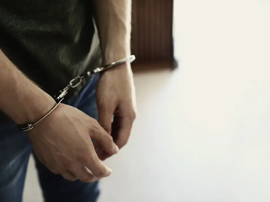 Junger Mann in Handschellen beim Strafvollzug im Jugendstrafrecht